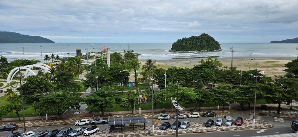 een parkeerplaats met geparkeerde auto's en een strand bij Vista incrível para o mar! in Santos