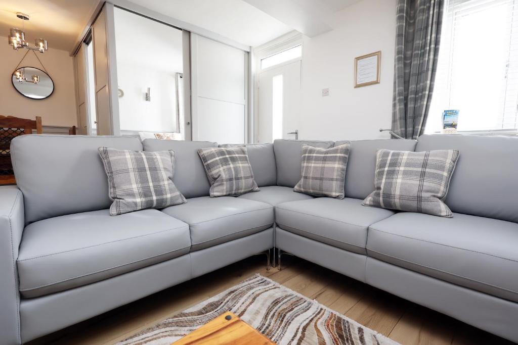 a living room with a gray couch with pillows at Cottage nr BikeParkWales/Brecon Beacons/PenYFan in Merthyr Tydfil