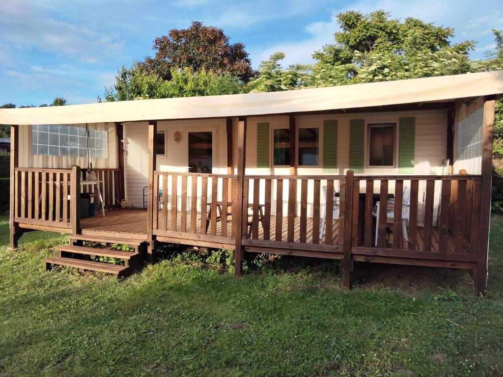 une petite maison avec un porche et une terrasse dans l'établissement Mobil Home for chilling out Camping Park ***, à Foix