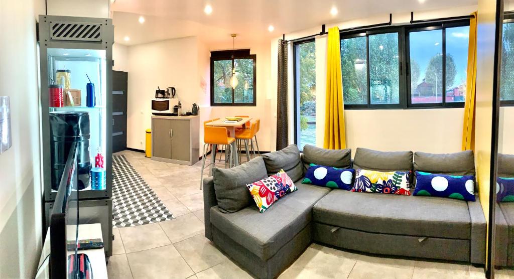 un salon avec un canapé et une cuisine dans l'établissement Apartment rooftop stadium of France metro line 13, à Saint-Denis