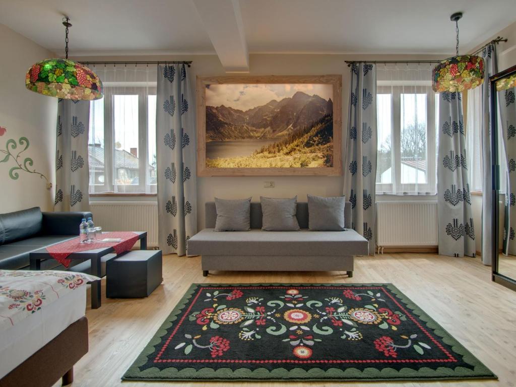 a living room with a couch and a painting on the wall at Pokoje Zamoyskiego - WATRA in Zakopane