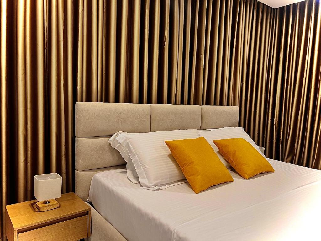 a bedroom with a bed with two yellow pillows at Dine Hotel in Ksamil