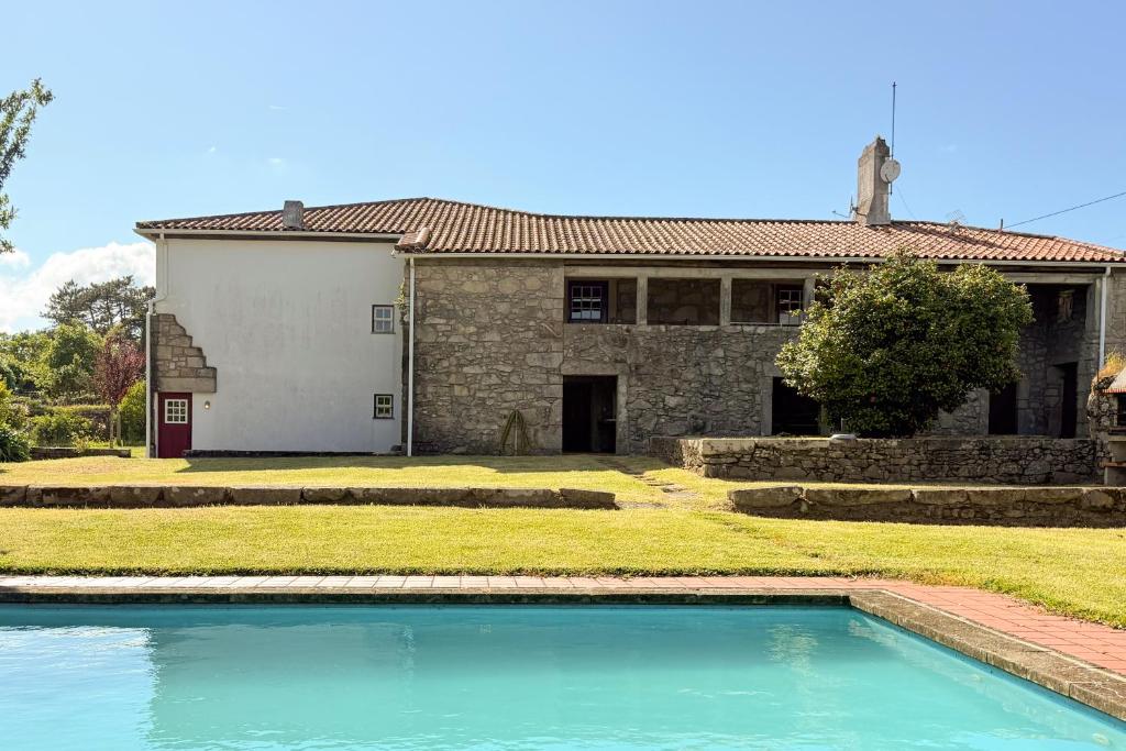 ein Haus mit einem Swimmingpool davor in der Unterkunft Casa das Pintoras Garden and Pool in Vila Praia de Âncora