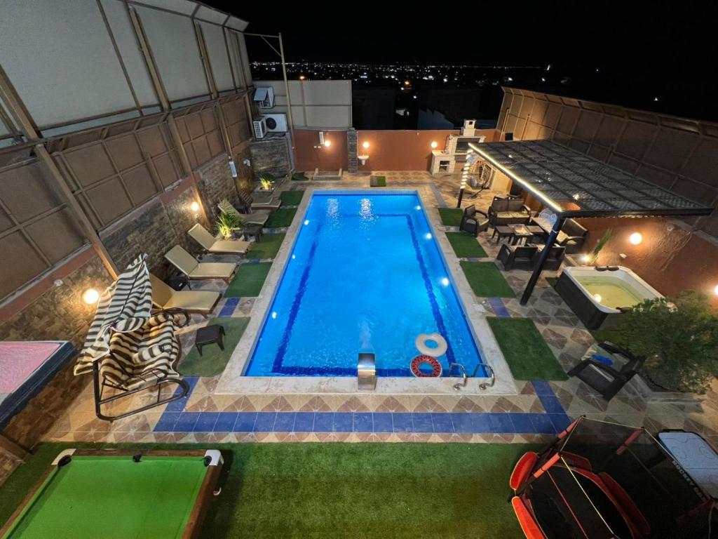 an overhead view of a swimming pool at night at Jordan Chalet in Ath Thughrah