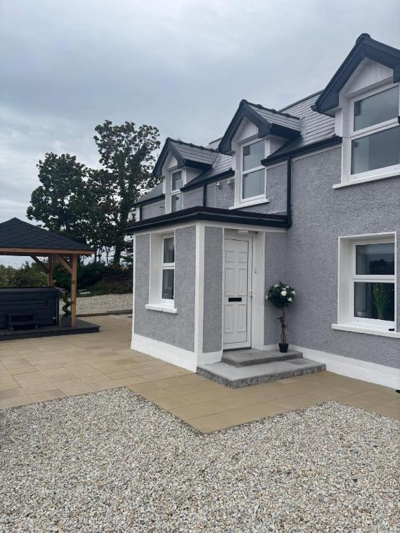 a house with a front door and a patio at Rose Cottage at Hilltop Hideaway in Barnesmore