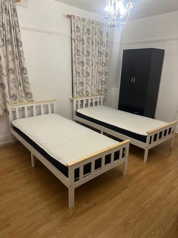 two beds are sitting in a room with at Day time room in London