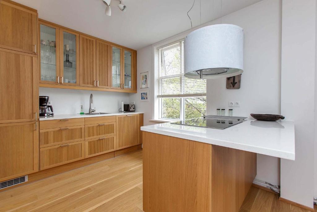 a kitchen with wooden cabinets and a white counter top at Sem Apartments in Reykjavík