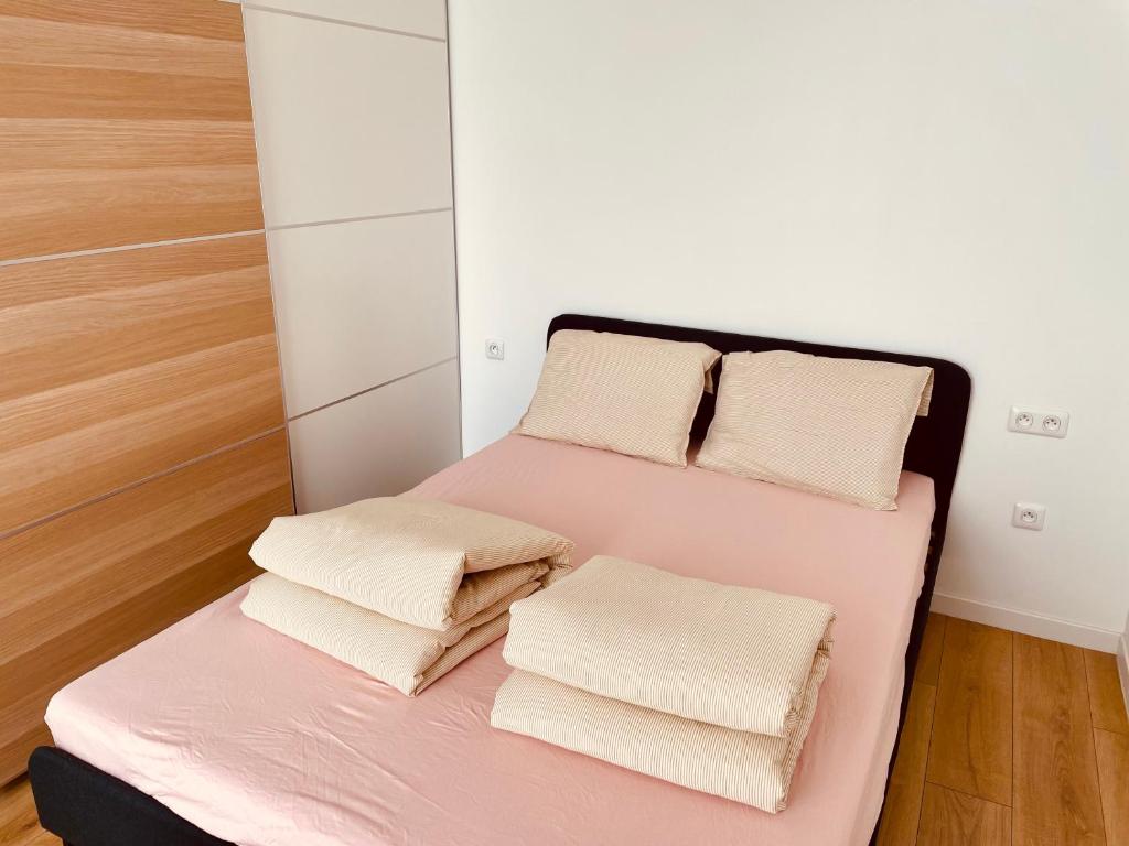 a small bedroom with a pink bed with three pillows at Z&L Villa Jardin - 2 Chambres 3 Lits - Maison familiale in Bourg-la-Reine