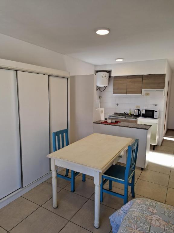 a kitchen with a table and chairs in a room at Depto moderno en pleno centro in Rosario