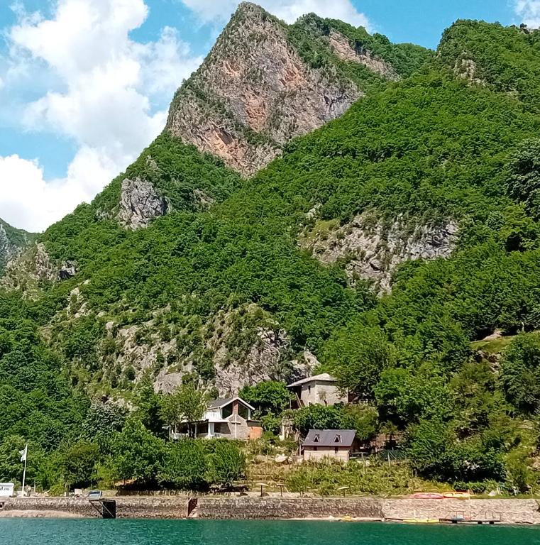 a mountain with houses next to a body of water at Norral shelter 1 in Kajvall