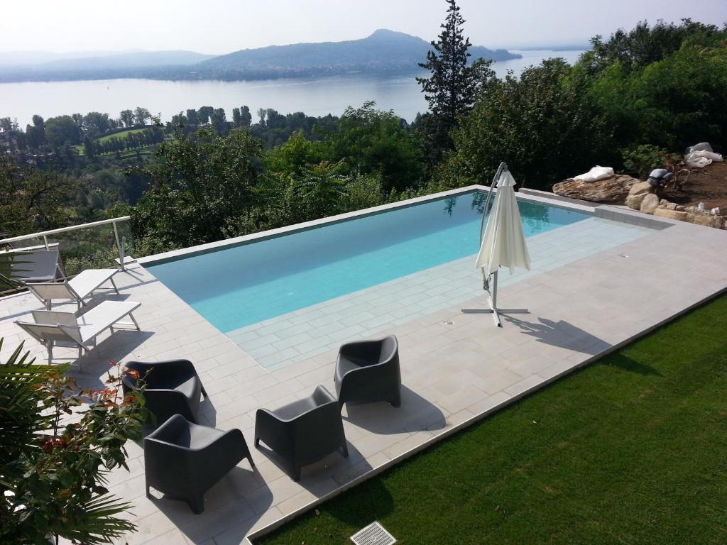 een zwembad met stoelen en een parasol bij Italian Lakes Apartment 14009 in Lesa