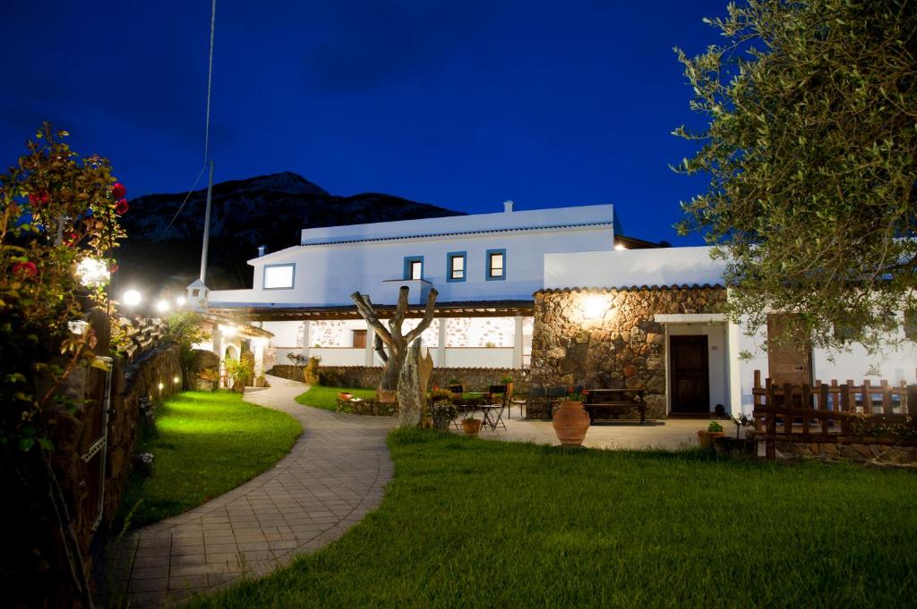 un bâtiment avec un chemin menant à une cour la nuit dans l'établissement Turismo Rurale Belvedere Pradonos, à Dorgali