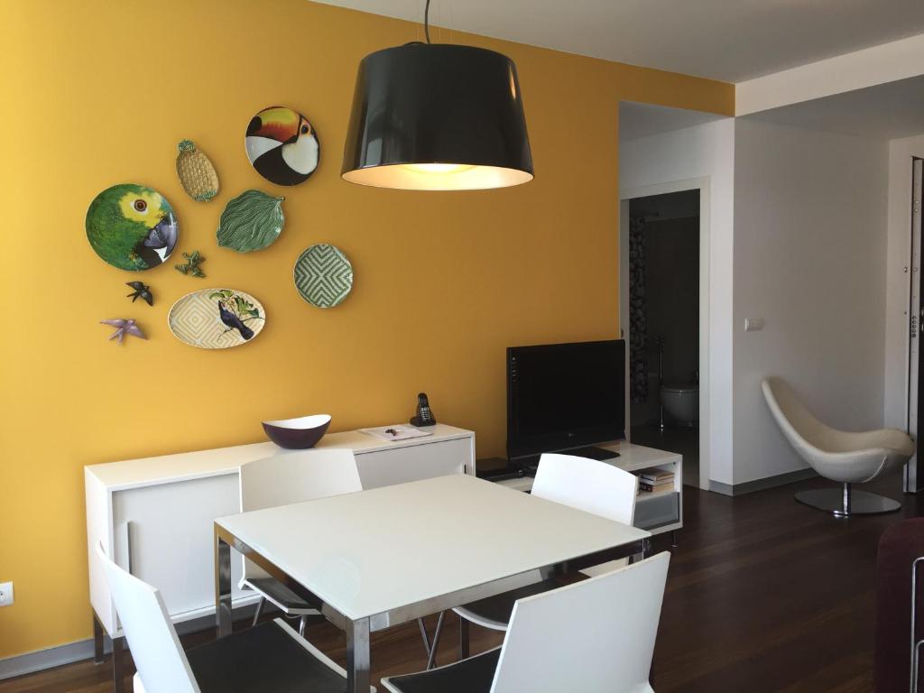 a dining room with a white table and white chairs at Funchal Centrum Apartments - Downtown in Funchal