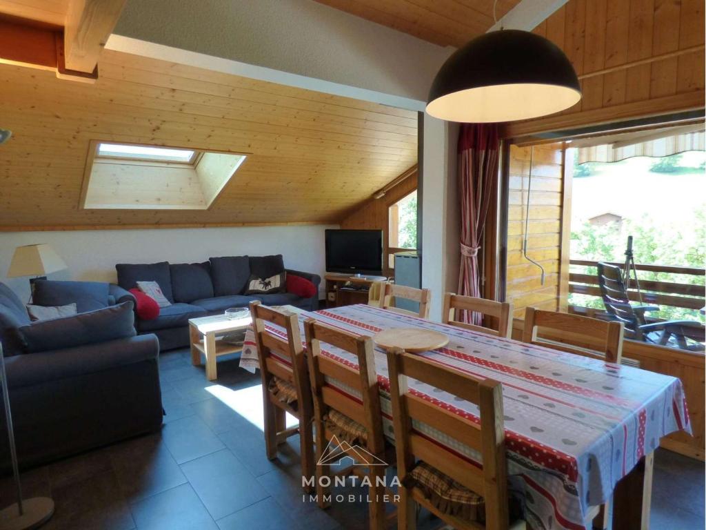 un salon avec une table et un canapé dans l'établissement Duplex 4 pièces + mezzanine pour 8 personnes au Grand-Bornand - FR-1-458-227, au Grand-Bornand