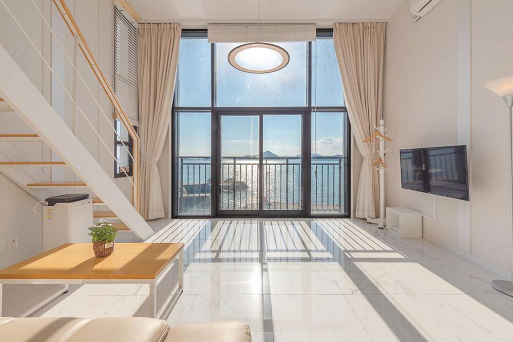 a living room with a large window with a view at Aramer Spa Pension in Yeosu