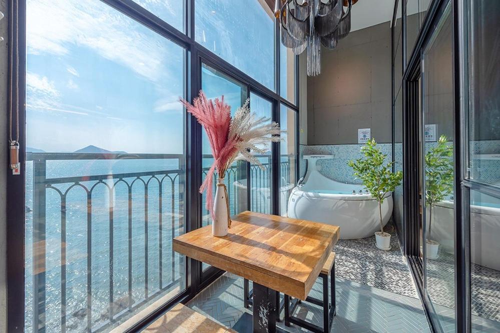 a bathroom with a view of the ocean from a balcony at Yeosu Yellow Sub Marine in Yeosu