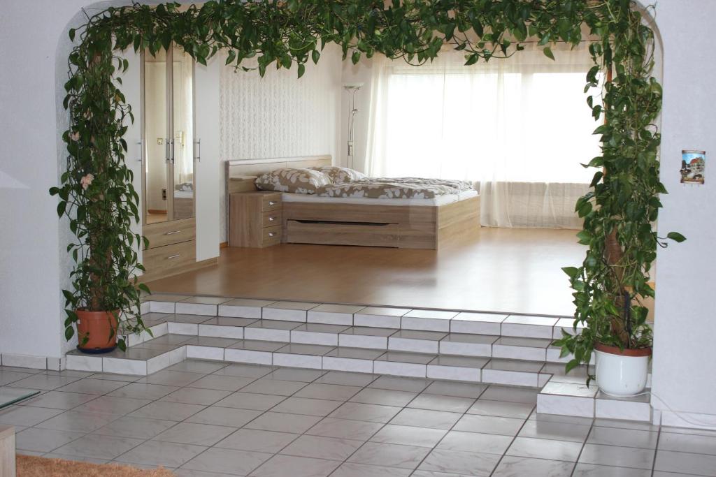 a room with a bed and an arch with plants at Ferienwohnungen Angela in Bad Marienberg