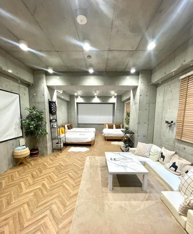 a living room with couches and a projection screen at 原田屋Hotel 3F in Tokyo
