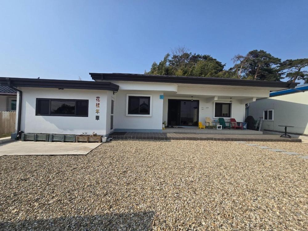 a house with a gravel driveway in front of it at Buan Hwayangyeonhwa Pension in Buan