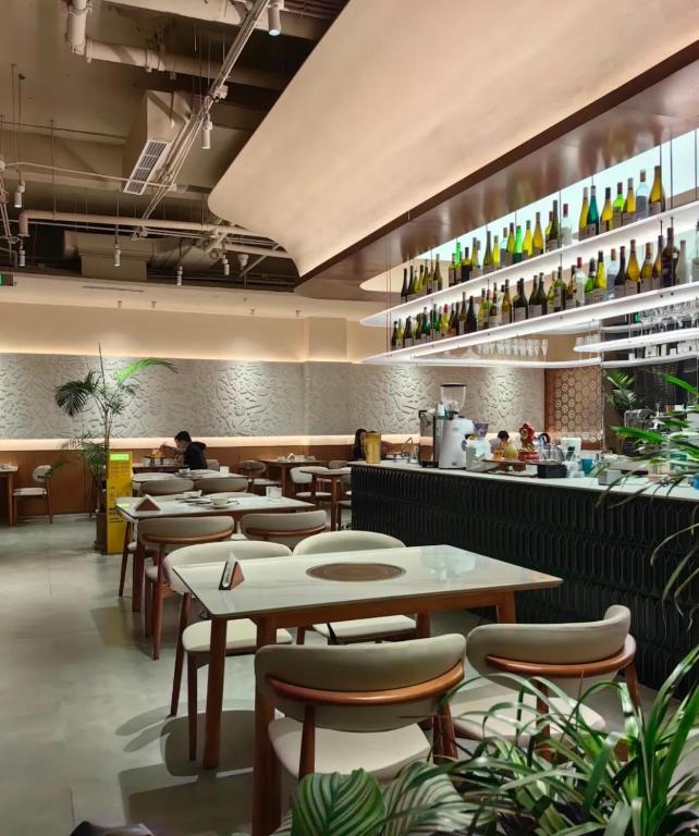 a restaurant with tables and chairs and a counter at base-Beijing Wangfujing Serviced Apartment- in Hutong &Bike rental &Close to Forbidden City, Tian'anmen Square &Subway nearby &Free coffee &Washing machine,Kitchen &Restaurant discount &English speaking &High speed free WiFi in Beijing