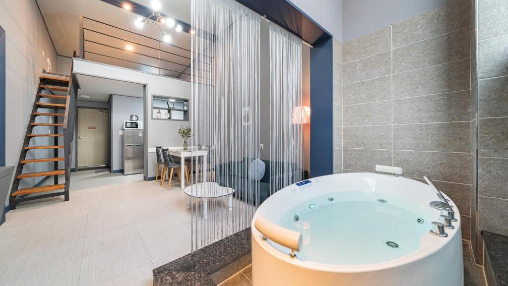a bathroom with a bath tub and a kitchen at Gyeongju Bomun Arno Pet-friendly Pool Villa in Mulch'ŏn