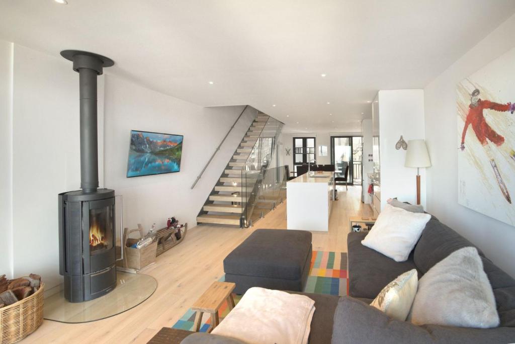 een woonkamer met een bank en een open haard bij Kabuki 2 - The Residence in Mount Buller