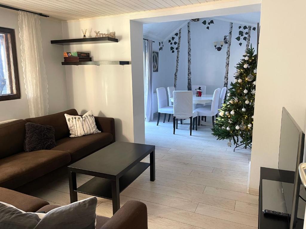 a living room with a couch and a table with a christmas tree at The Nest in Sinaia