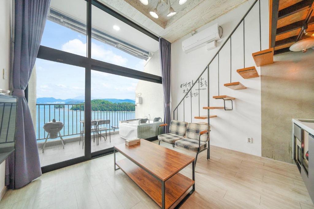 a living room with a view of the water at Yeosu Bokja Pension in Yeosu