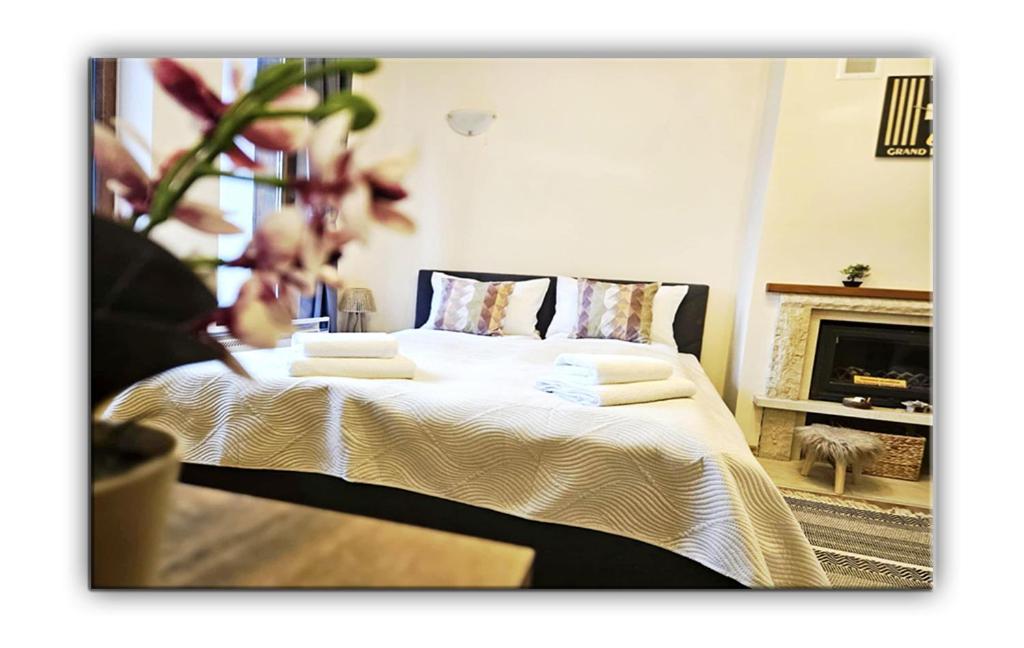 Un dormitorio con una cama con sábanas blancas y una chimenea. en Grand Studio B27, en Pamporovo