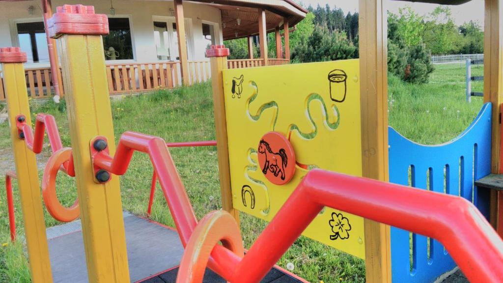 a playground with colorful play equipment in a yard at Farma Slunečný Dvůr in Hermanuv Mestec