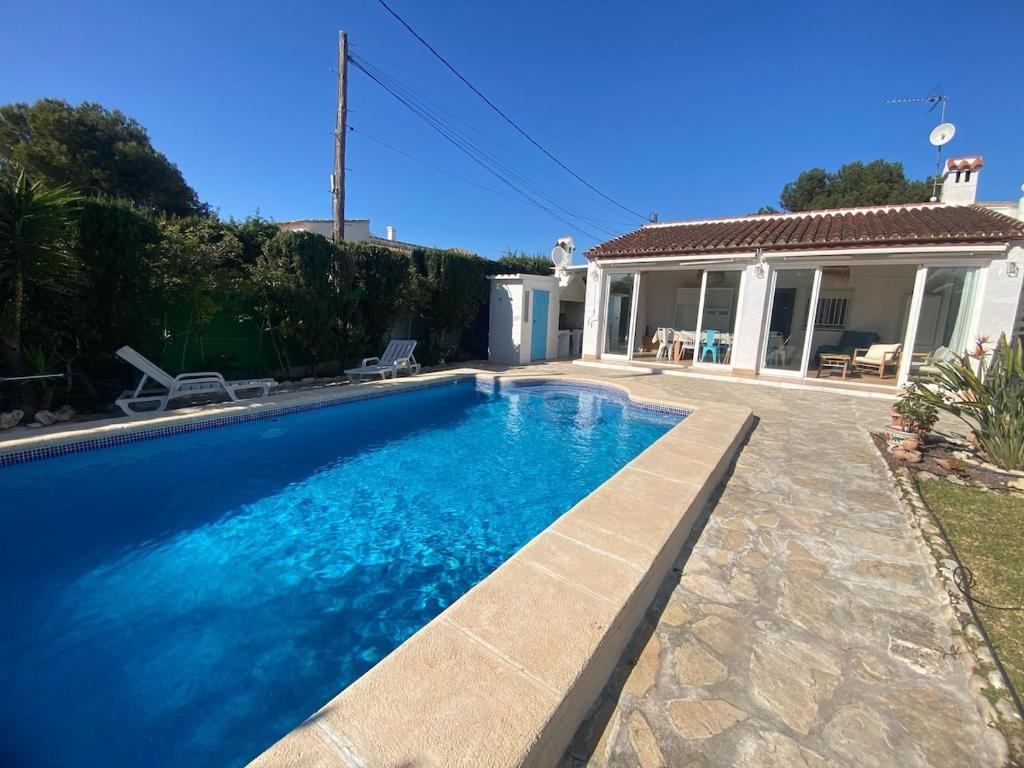a swimming pool in front of a house at Terreta de Denia in Denia