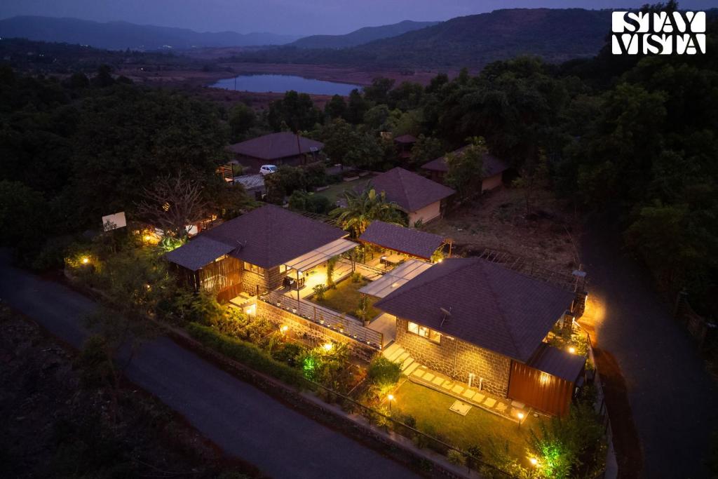 an overhead view of a house at night with lights at StayVista at Hearth & Haven with lawn, BBQ in Pune