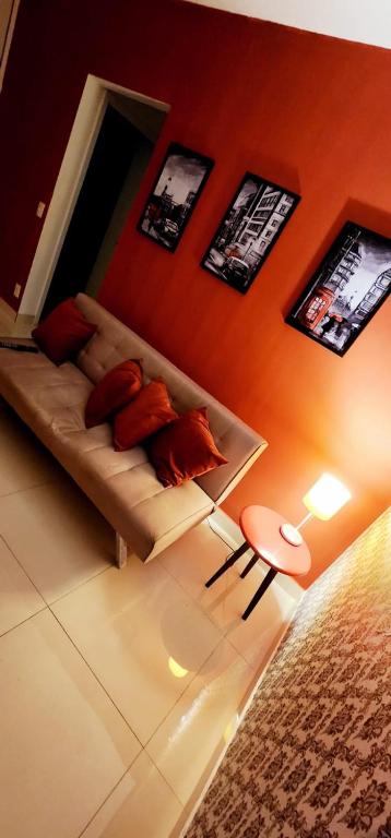 a living room with a couch and pictures on the wall at Apto novíssimo prox Alphaville e ginásio barueri in Jandira