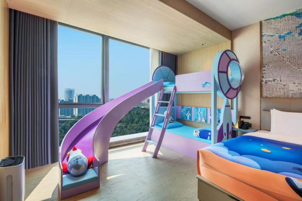 1 dormitorio con litera y tobogán en Guangzhou Meihua Hotel, en Huadu