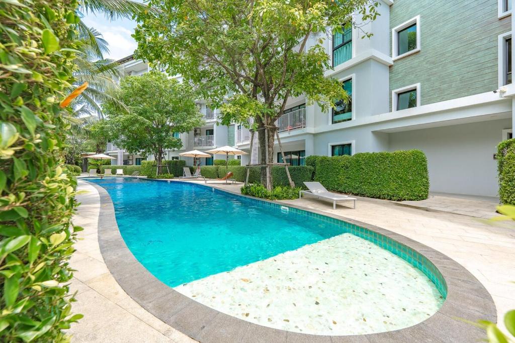 a swimming pool in front of a building at C188 Modern Condo Pool Gym & Walk to Rawai Beach in Rawai Beach