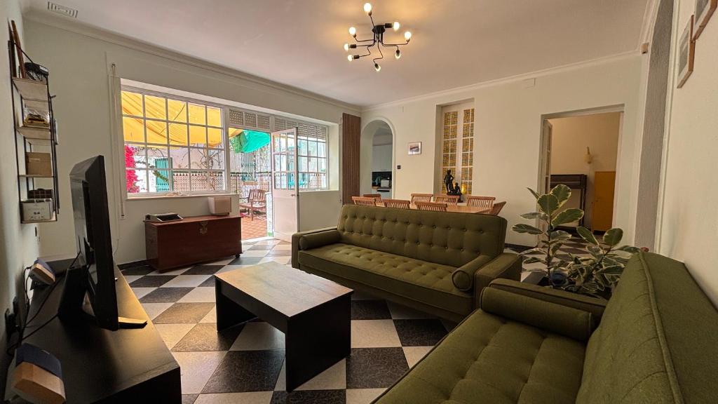 a living room with a couch and a tv at Patios de la Carmela in Isla Cristina