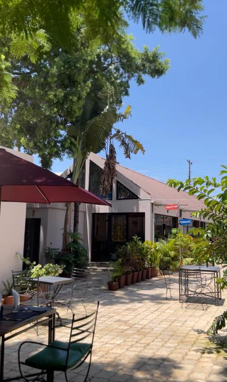 a patio with tables and chairs in front of a building at Au Mirandav Hotel in Ambohidratrimo