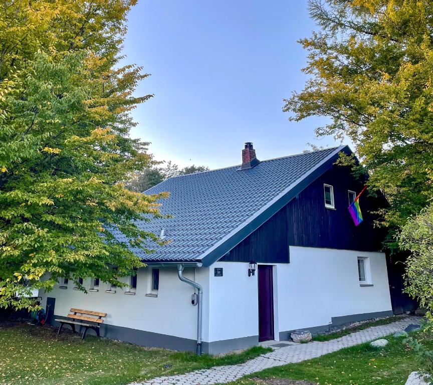 eine schwarz-weiße Scheune mit einer weißen Garage in der Unterkunft Spirkenhütte Fichtelberg - Ferienhaus bis 6 Personen - mit Sauna - am Fichtelsee in Fichtelberg