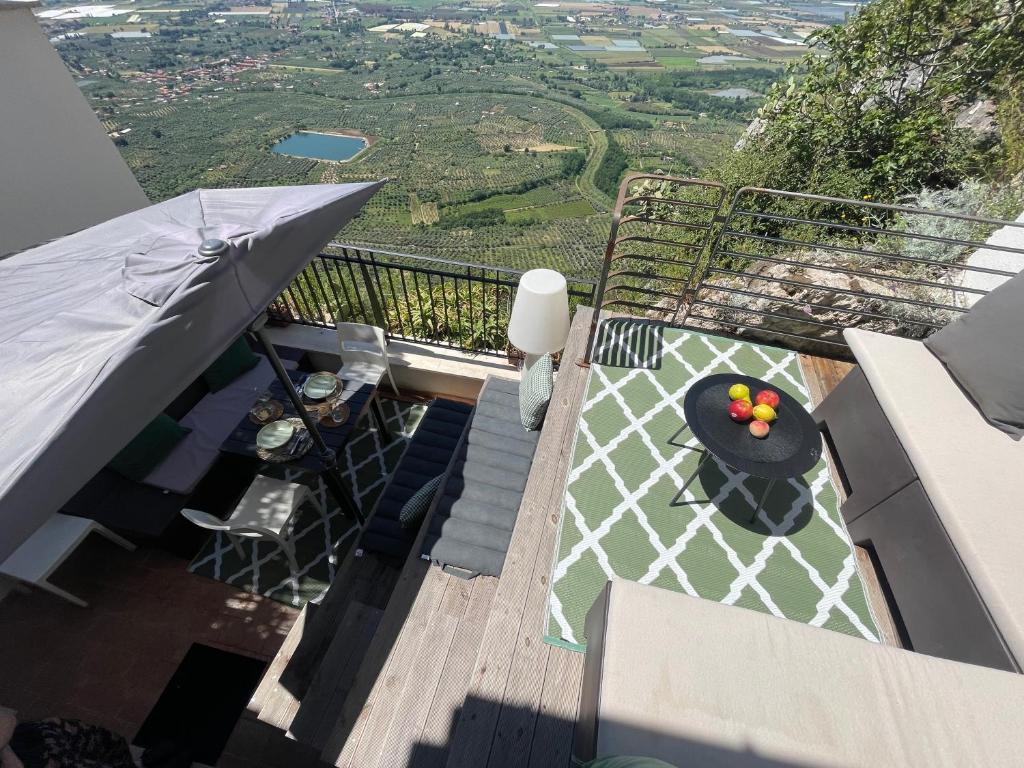 a balcony with a table with a bowl of fruit on it at Stalla suite con living esterno vista mozzafiato in Norma