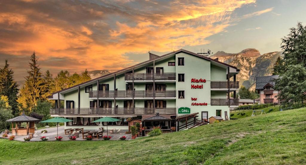 a hotel in the mountains with a sunset at Hotel Alaska in Folgarida