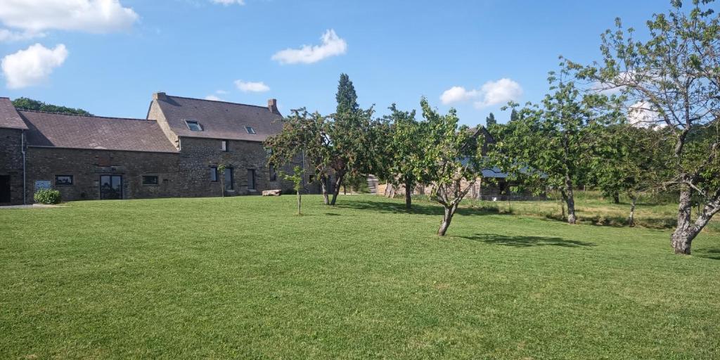 une grande cour avec des arbres devant un bâtiment dans l'établissement Pied à Terre, à Bain-de-Bretagne