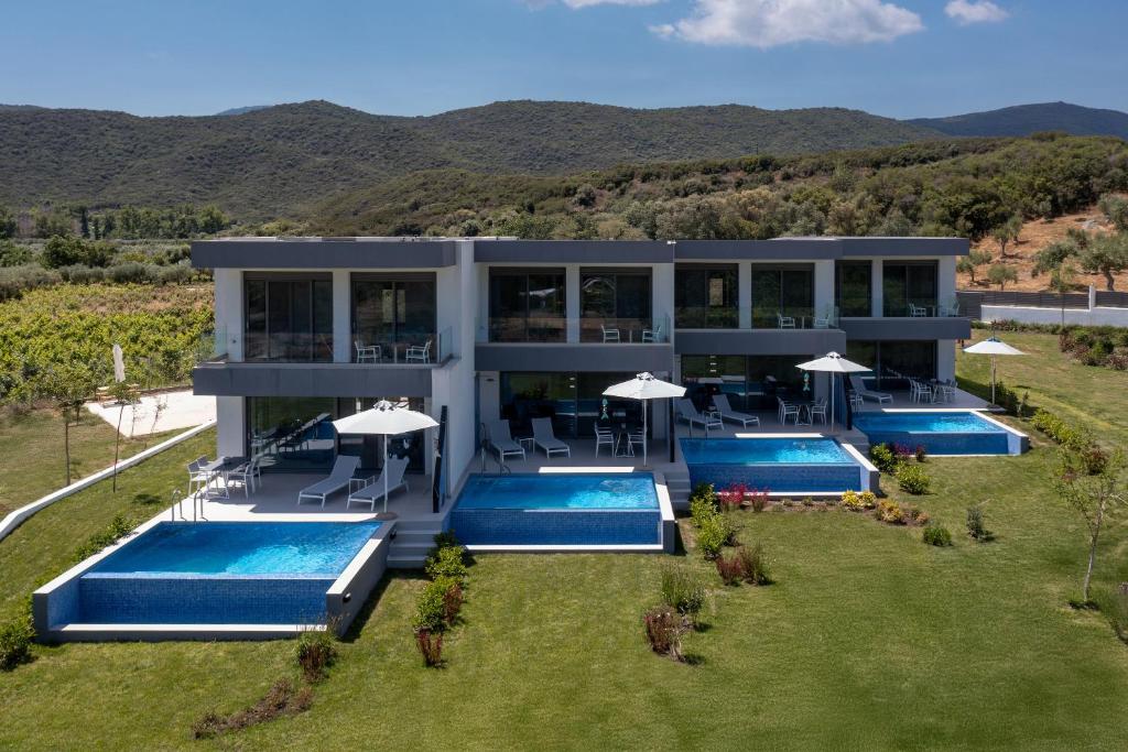 an aerial view of a house with two swimming pools at ELYSIUM VILLAS Quartet in Sarti