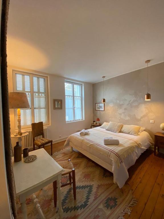 une chambre avec un grand lit et une table dans l'établissement Elégante maison près de la mer 1 ou 2 chambres, à Fécamp