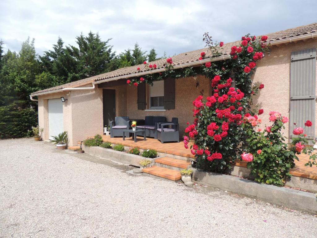 une maison avec des roses sur son côté dans l'établissement Villa au calme, à Eyguières