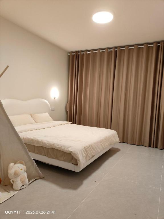 a bedroom with a bed with a teddy bear next to a window at Yangshuo Chechen in Yangshuo