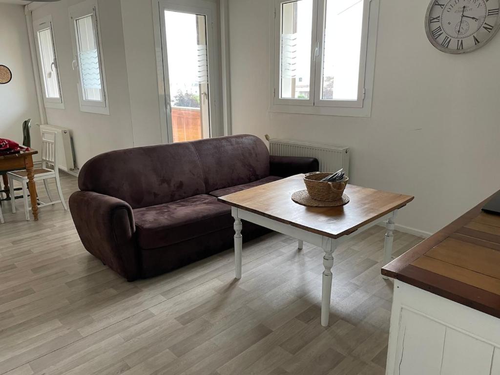 un salon avec un canapé et une table dans l'établissement Spacious apartment in Guingamp, à Guingamp