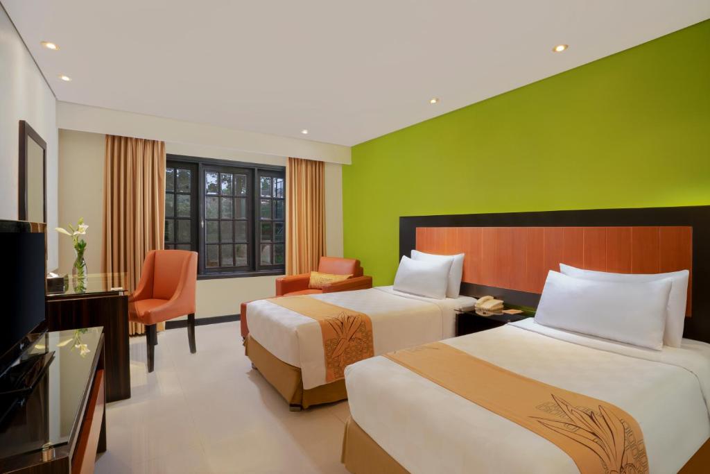 Postel nebo postele na pokoji v ubytování Loman Park Hotel Yogyakarta