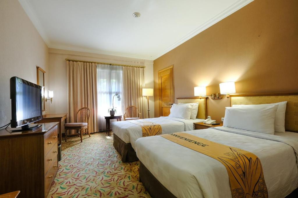 Postel nebo postele na pokoji v ubytování Loman Park Hotel Yogyakarta