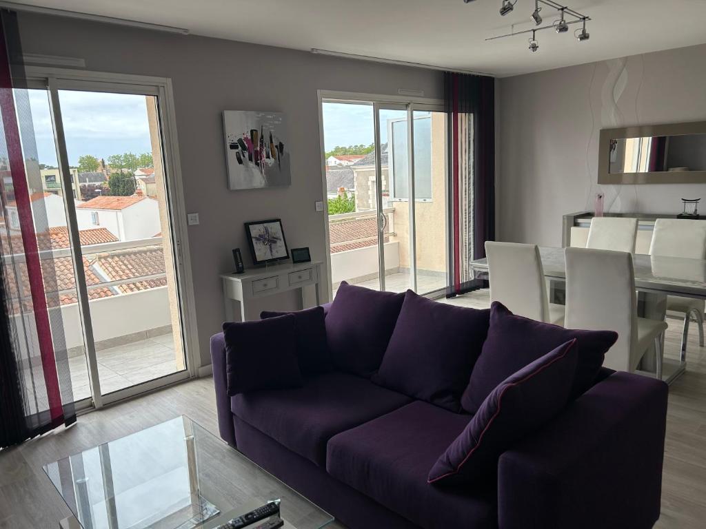 a living room with a purple couch and a table at Appartement ST JEAN Centre Ville Wifi Balcon Parking in Saint-Jean-de-Monts