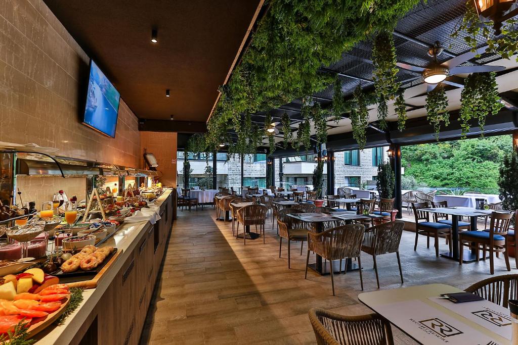 a restaurant with a buffet line with tables and chairs at Regent Resort Budva in Budva